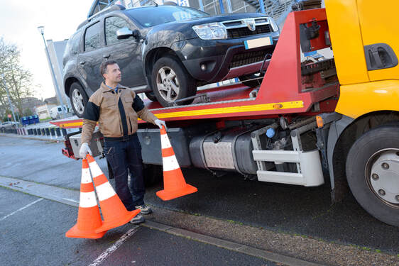 Tow truck operator using orange safety cones